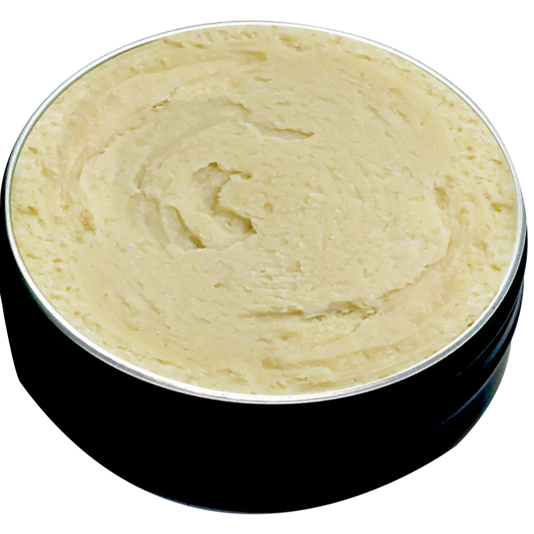 Open tin of thick beige balm with creamy texture in a black round container