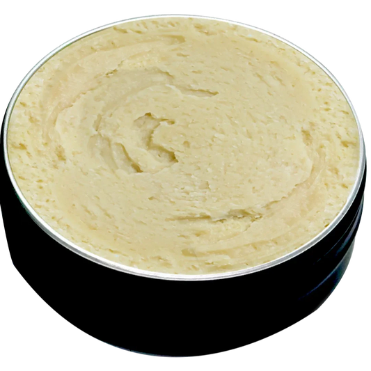 Open tin of thick beige balm with creamy texture in a black round container
