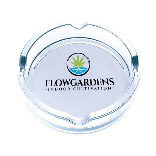 Clear glass ashtray with Flowgardens logo on a white background