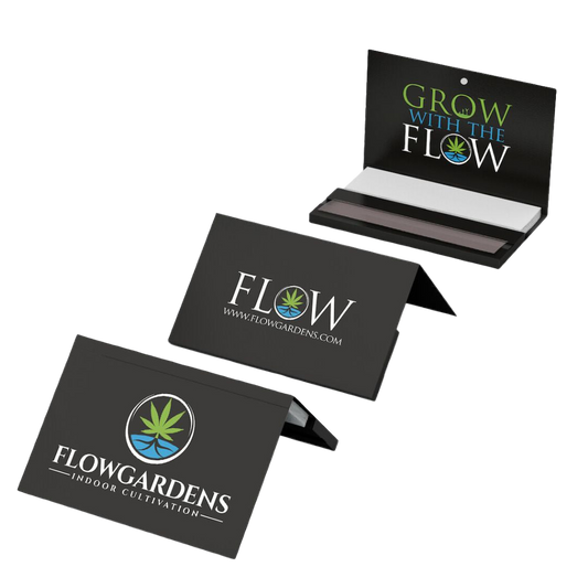 Black packs of white rolling papers with 'Flowgardens' branding