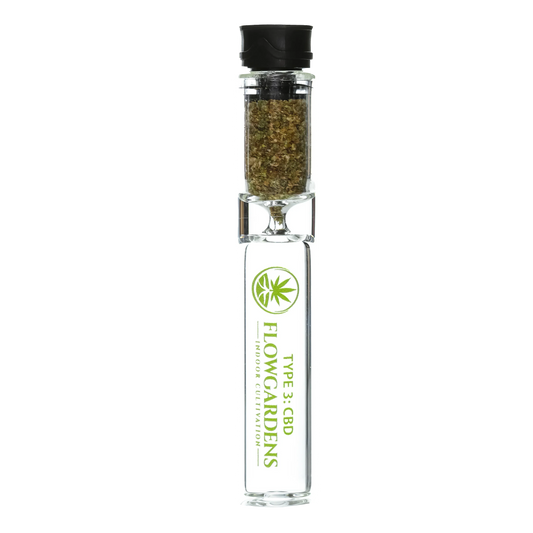 Clear glass chillum pipe with CBD flower, Flow Gardens branding, black cap, isolated on white